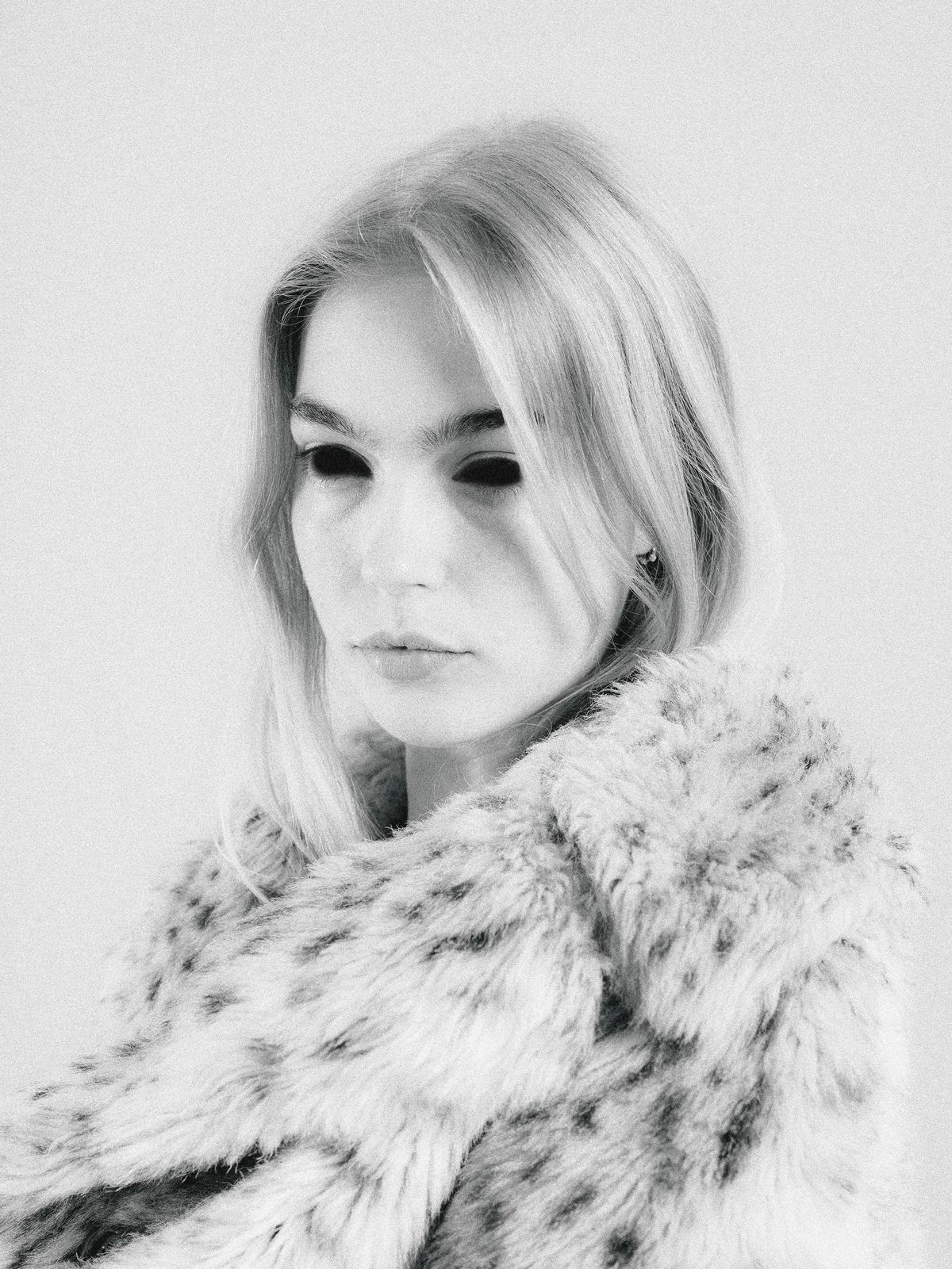Portrait en noir et blanc d'une femme blonde dans un manteau en fourrure