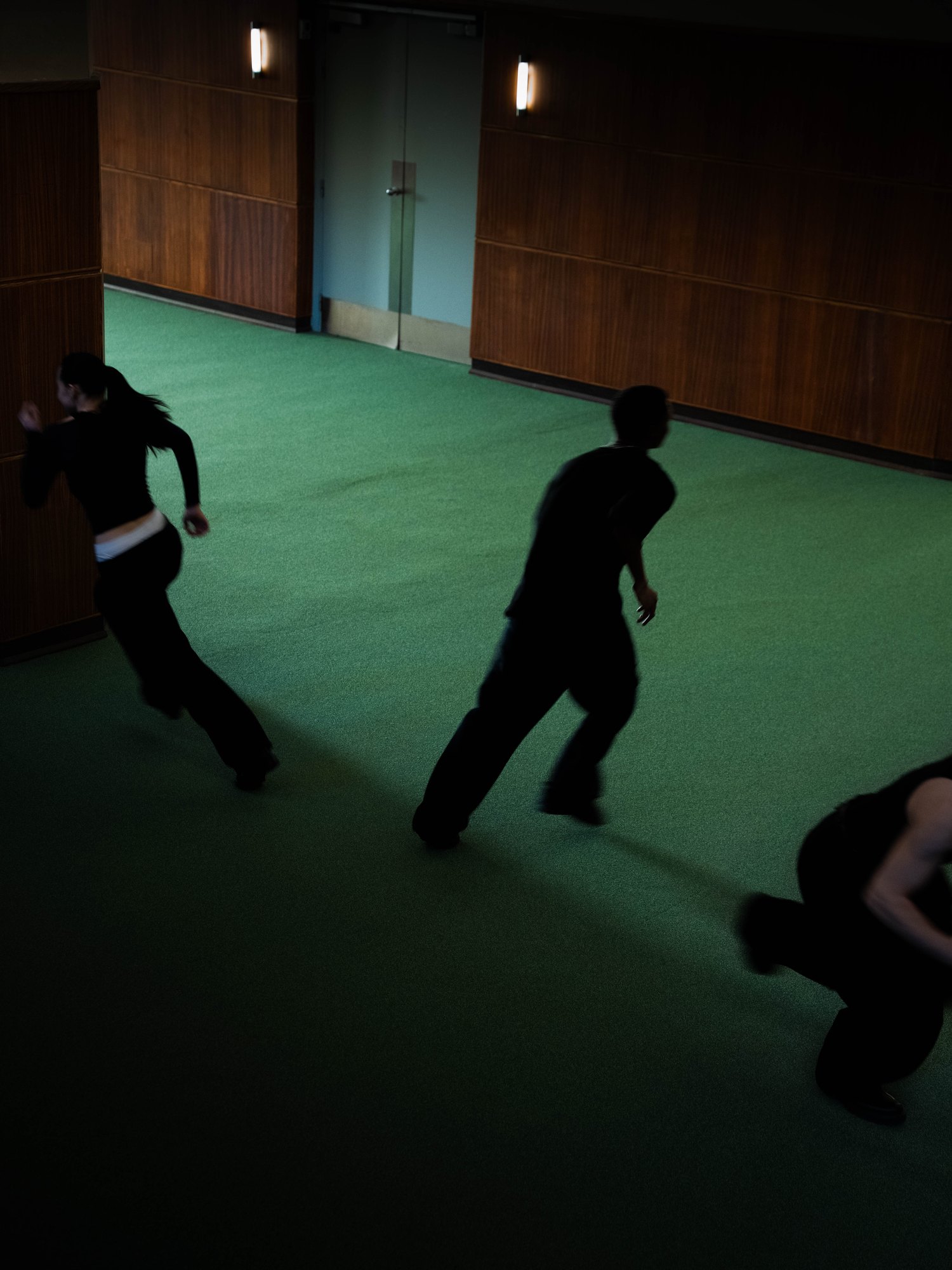 Trois danseurs courant sur une moquette verte