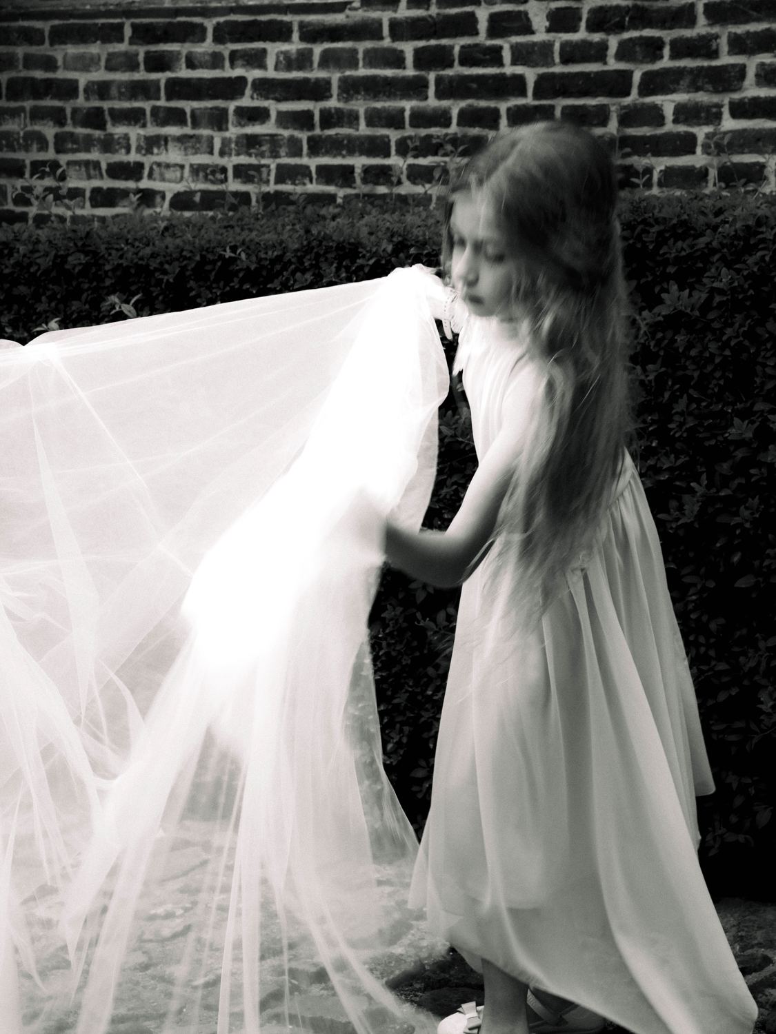 Fillette tenant le voile de la mariée, noir et blanc