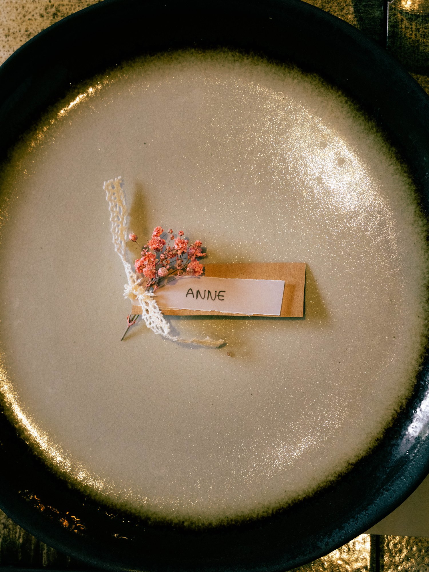 Place à table avec un petit bouquet séché et un marque-place au prénom d'Anne